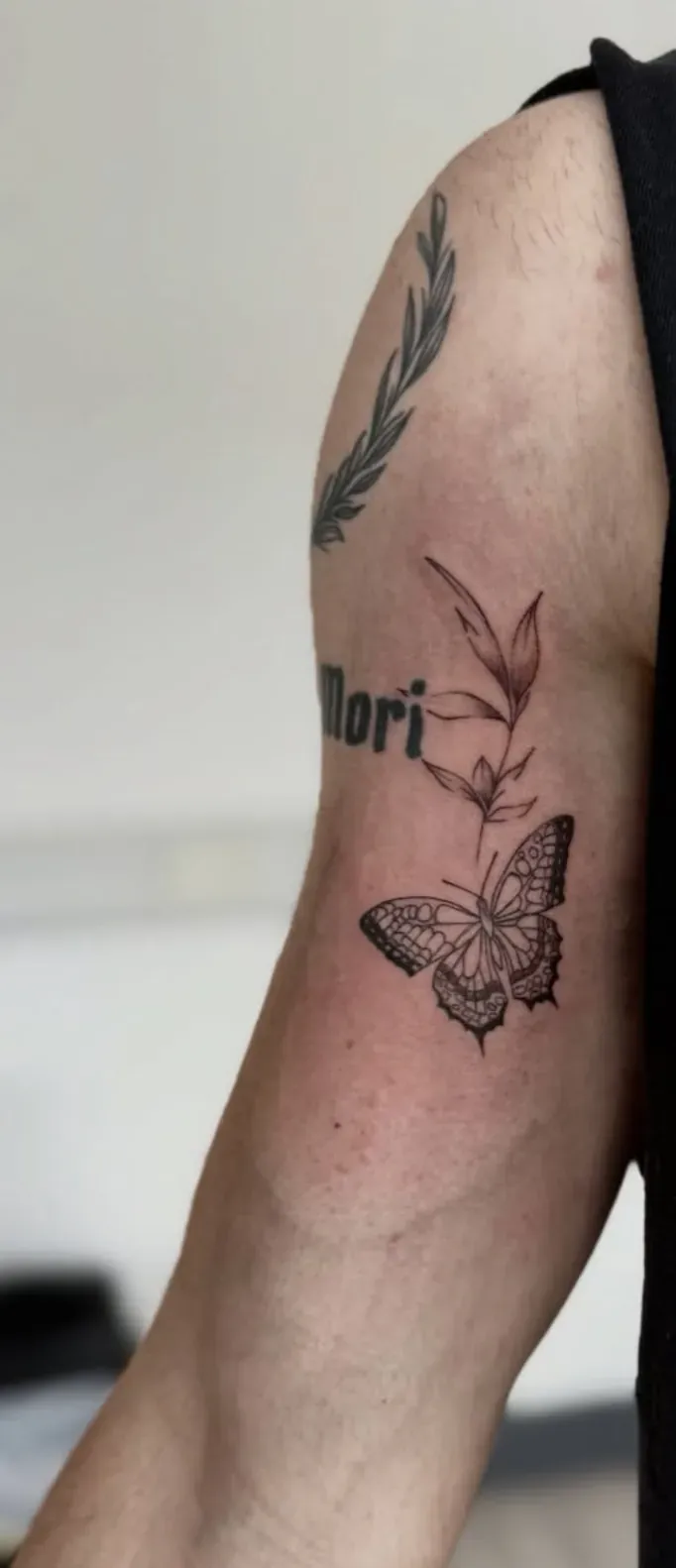 Shaded butterfly and leafy stem on the upper arm