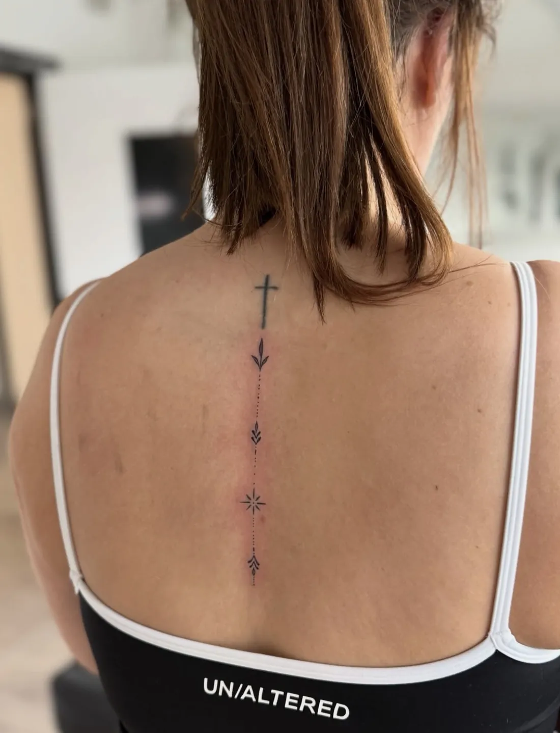 Small cross with ornamental dotted details down the spine