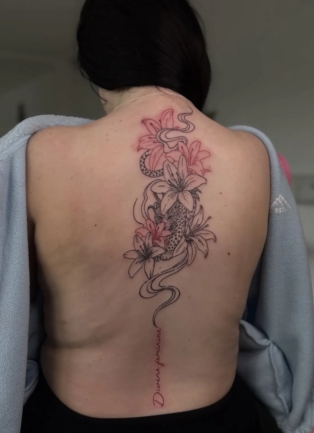 Leopard among black and red lilies down the spine with Divine feminine script